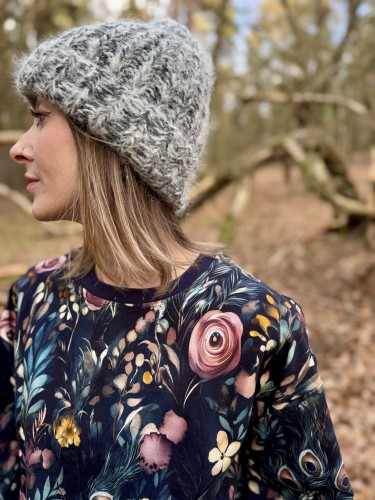 Wzór pawich piór i kwiatów — detal materiału bluzy
